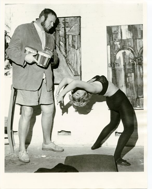 Item #SKB-17050 Original photograph of Eric Nord playing bongos while a beatnik woman in black tights and bra dances next to him with abstract paintings on the wall, ca. 1960. Eric NORD.